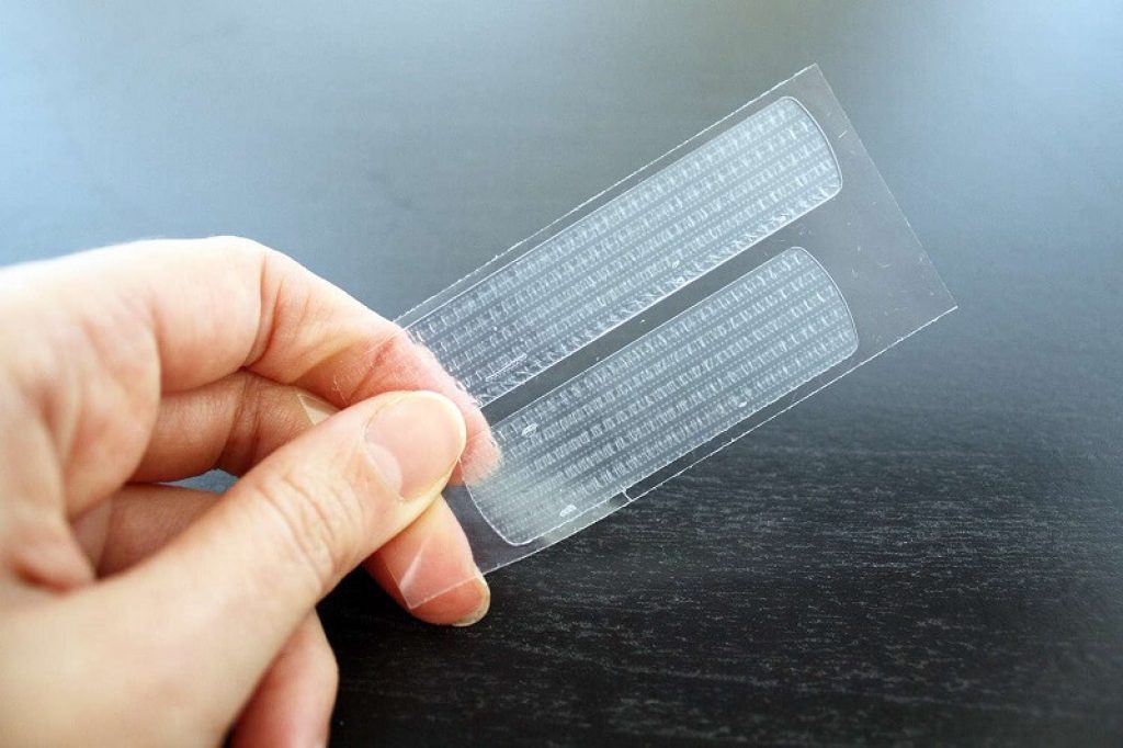 Två tandblekningsremsor på plastfilm