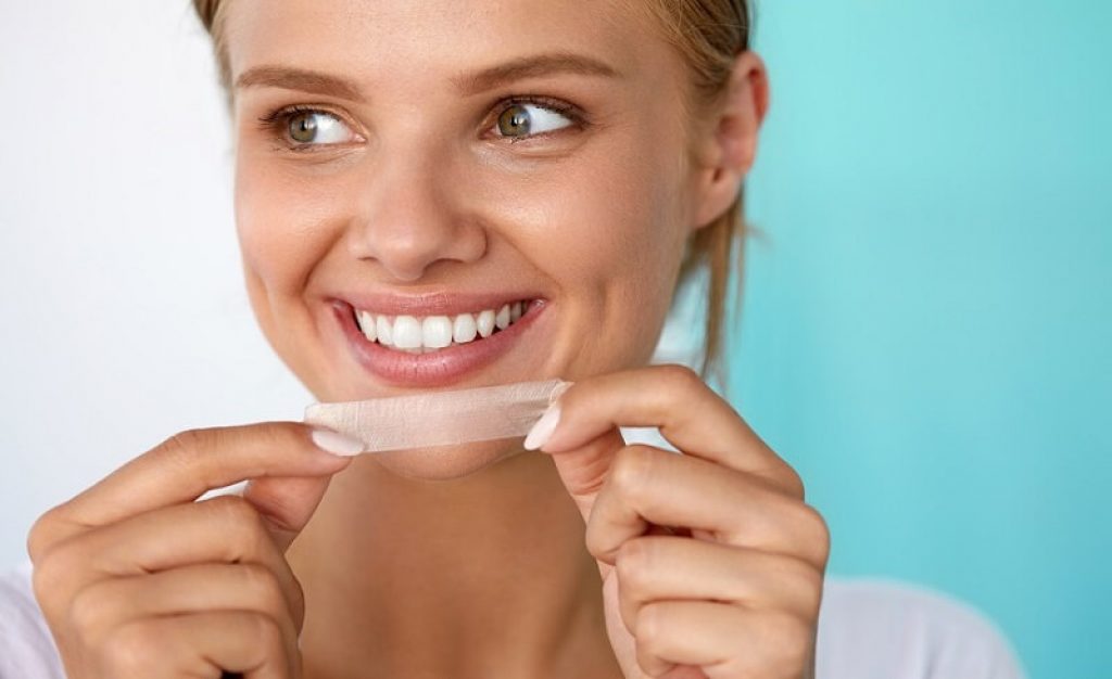 Kvinna med tandbleknign strips